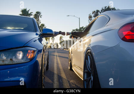 M-Serie BMW Fist Bump mit Sonnenuntergang und Palmen Stockfoto