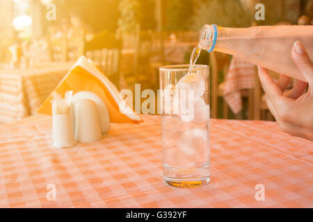 : Gießen Wasser in das Glas auf den Tisch im restaurant Stockfoto