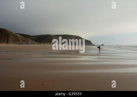 Portugal, Algarve, Surfer zu Fuß an der Praia do Amado Strand, Dämmerung Stockfoto