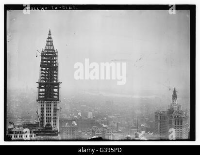 Der Turmbau für das Woolworth Building am Broadway in New York City, das im April 1913 fertiggestellt wurde. Auf der rechten Seite ist das Municipal Building, auch im Bau, mit den East River in den Hintergrund. Stockfoto