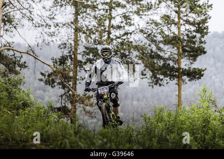 Athlet Mountainbiker im Wald Berge im Hintergrund während Cup "Ryder" bergab Stockfoto