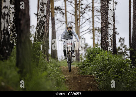 Mädchen-Mountainbiker auf Fahrrad reitet auf dem richtigen Weg im Wald während Cup "Ryder" bergab Stockfoto