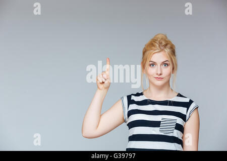 Niedlich schönen jungen Frau stehen und nach oben auf weißem Hintergrund Stockfoto