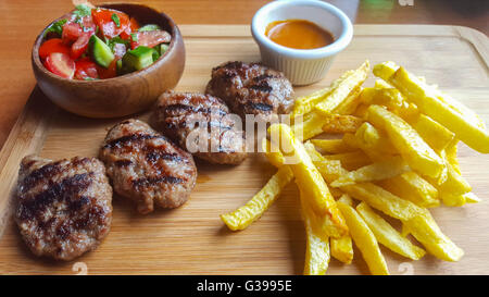 Türkische Frikadellen mit Gemüse und Pommes frites serviert. Stockfoto