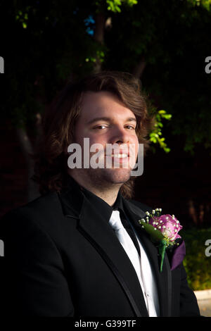 Porträt eines Mannes an seinem Hochzeitstag.  Er trägt eine rosa, rose Boutonniere und hat eine rautenförmige Ohrringe in sein rechtes Ohr. Stockfoto