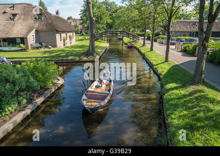 Giethoorn, Niederlande. Elektroboot im Dorpsgracht oder im Dorf Kanal mit romantischen jungen chinesischen Ehepaar im Juni. Stockfoto