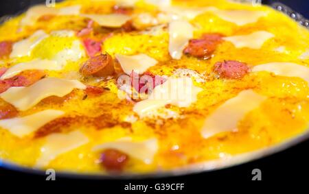 Schinken und Ei mit Käse Pfanne, Würstchen und Pfeffer bestreut mit Kümmel Closeup. Stockfoto