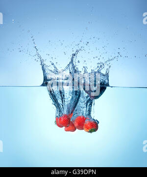 Erdbeere fallen und ins Wasser plätschern. Stockfoto