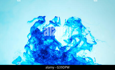 ein Wirbel von blauer Tinte im klaren Wasser. Stockfoto