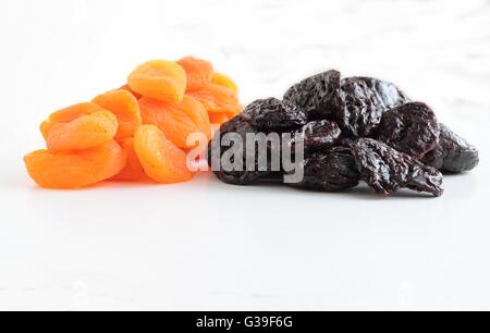 Getrocknete Pflaumen und Aprikosen Obst auf weißem Hintergrund Stockfoto