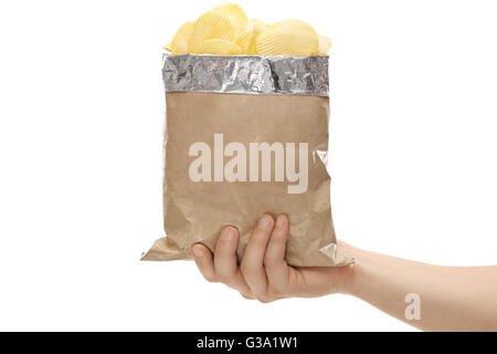 Close-up auf eine Hand, die eine braune Tasche voller Kartoffelchips isoliert auf weißem Hintergrund Stockfoto