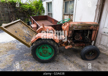 Alten Oldtimer-Traktor Rost entfernt außerhalb in der Nähe das Dorfhaus Stockfoto