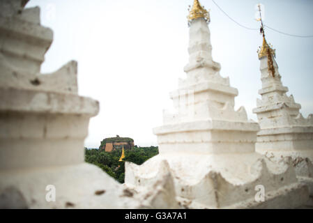 MINGUN, Myanmar (Birma) — Mingun Pahtodawgyi in der Ferne von der Hsinbyume-Pagode aus gesehen. Die Hsinbyume-Pagode wurde 1816 erbaut und befindet sich in Mingun, nicht weit von Mandalay entfernt. Sie wurde nach dem Vorbild des buddhistischen mythologischen Berges Mount Meru entworfen. Es verfügt über 7 Stufen unverwechselbarer und einzigartiger weißer Wellen. Stockfoto