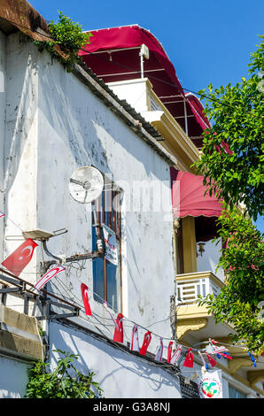 Türkische Flaggen auf Bunting hängen Seite ein Gebäude in der Stadt Kyrenia, Nordzypern. Stockfoto