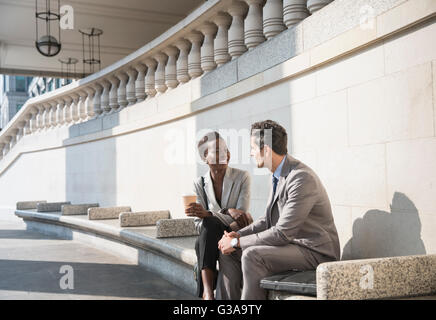 Corporate Geschäftsmann und Geschäftsfrau genießen Kaffeepause auf sonnigen Treppe Stockfoto