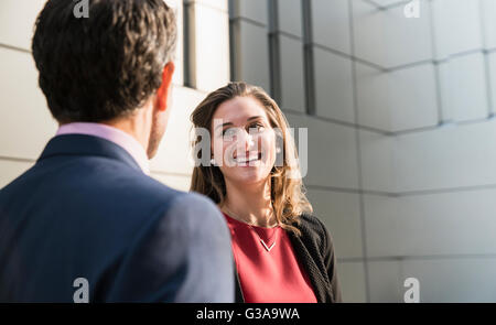 Corporate Geschäftsfrau Lächeln auf den Lippen und im Gespräch mit Geschäftsmann Stockfoto