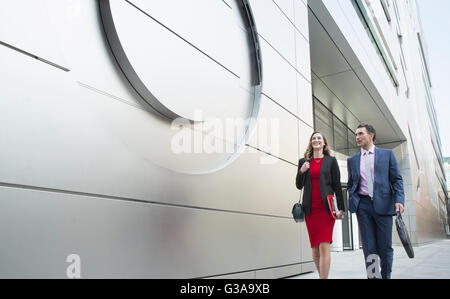 Unternehmen Unternehmer und Unternehmerin zu Fuß außen modernes Gebäude Stockfoto