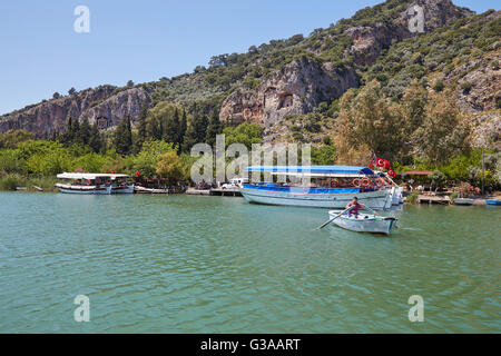 Boote am Fluss Dalyan Çay mit den lykischen Gräbern in den Klippen über, Türkei. Stockfoto