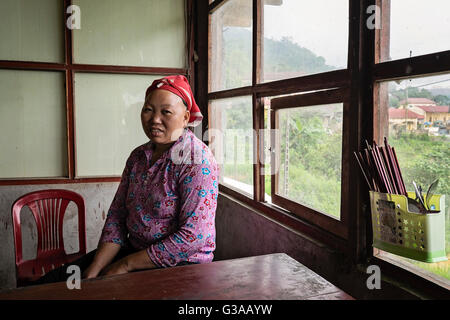 Eine rote Dao-Frau sitzt in einem Café im Dorf Ban Khoang, Sapa, Provinz Lao Cai, Vietnam Stockfoto