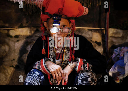 Eine Frau mittleren Alters roten Dao verkauft Stammes-Kunsthandwerk auf einer Straße Nachtmarkt in Sapa, Provinz Lao Cai, Vietnam Stockfoto