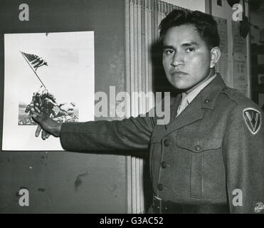 Marine Private First Class Ira Hayes zeigt das Teil spielte er in der Ansammlung von Stars And Stripes auf Mount Suribachi, Iwo Jima mit dem Hinweis auf sein Bild auf dem historischen Foto des Ereignisses. Stockfoto