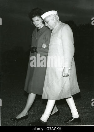 Frau Jacqueline Kennedy, Frau des Präsidenten Kennedy, geht Arm in Arm mit Premierminister Jawaharwal Nehru in Indien, da sie einen Hubschrauber zu verlassen und den Rasen des weißen Hauses überqueren. Stockfoto