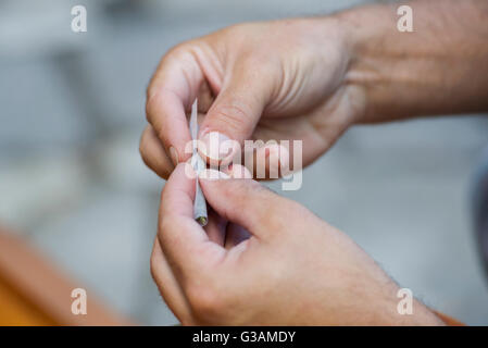 Ein Mann rollt ein Cannabis-Gelenk in Montreal, August 2014. Foto Graham Hughes/freiberufliche Stockfoto