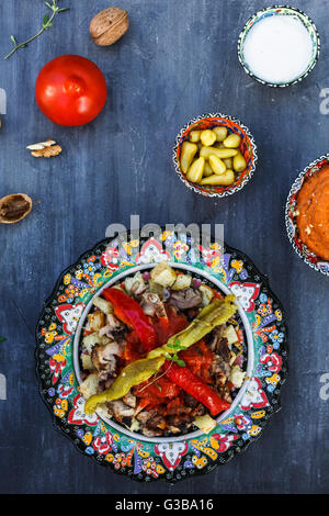 Traditionelle türkische Bursa Iskender Kebap Döner serviert mit speziellen roten Sauce und Joghurt in der Mitte, garniert mit gegrillten, Stockfoto