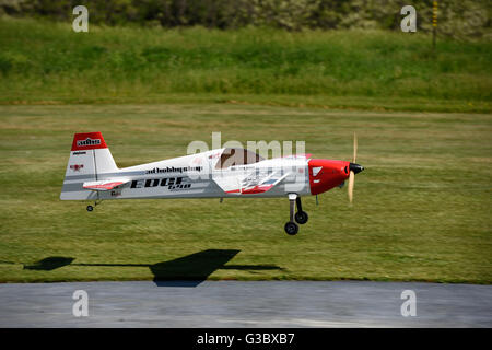 Einzelne Prop Gas Motor RC Flugzeug Landung in einer Wiese Stockfoto