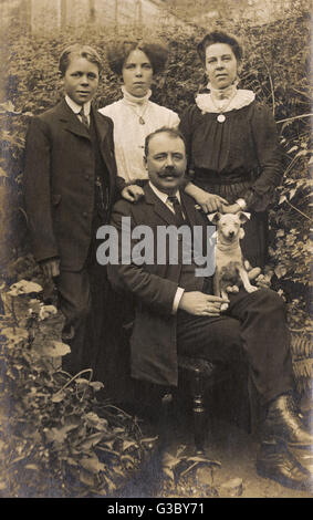 Vierköpfige Familie und Hund im Garten Stockfoto