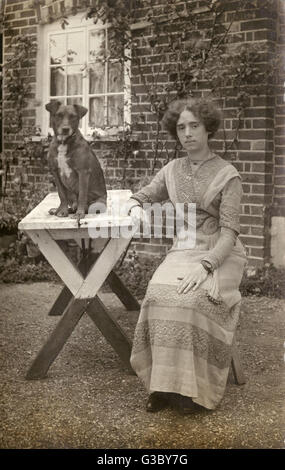 Junge Frau und Hund im Garten Stockfoto