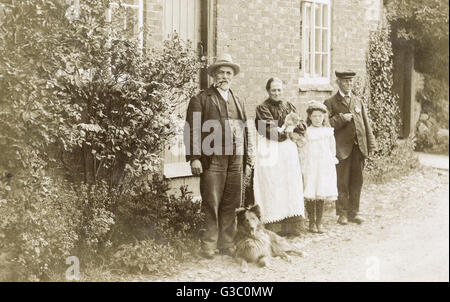 Vier Leute, eine Katze und ein Hund in einem Garten Stockfoto