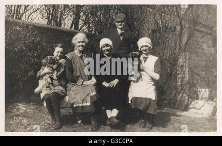 Familiengruppe mit zwei Hunden in einem Garten Stockfoto