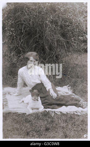 Junge Frau mit Hund im Garten Stockfoto