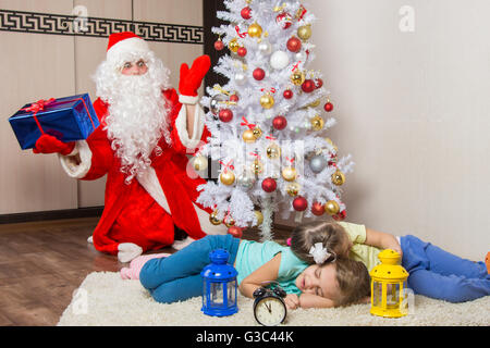 Santa Claus in New Years Eve war überrascht zu sehen die beiden schlafenden Kinder Baum Stockfoto