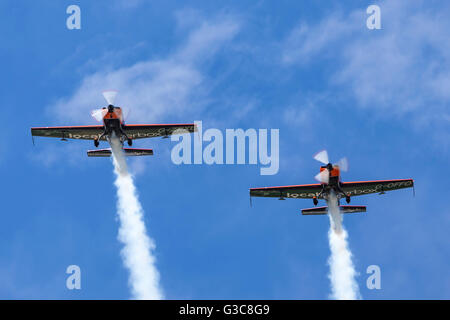 Klingen aerobatic Team bestehend aus ehemaligen Red Arrows-Piloten fliegen Extra EA - 300L Kunstflug Flugzeug auf der RAF Waddington Airshow Stockfoto