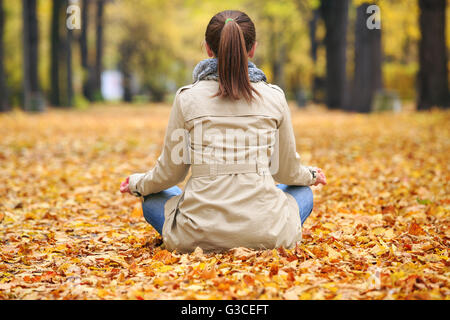 Frau Meditierenden im Herbst park Stockfoto