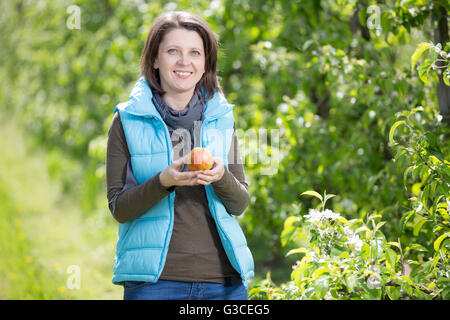 Wunderschöne lächelnde Frau im Obstgarten Stockfoto