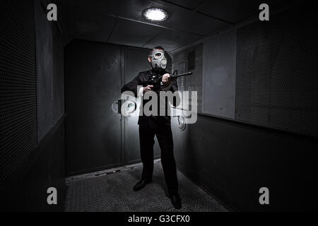 Mann mit Gewehr und Gasmaske im alten Aufzug Stockfoto