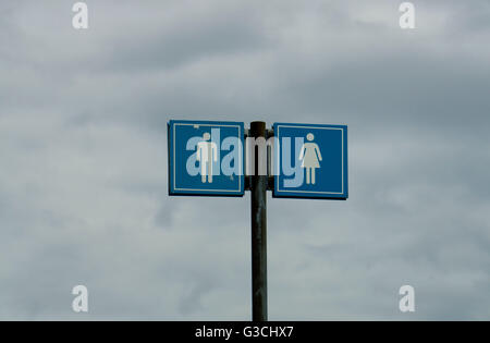 Öffentliche Toilette Schild in blau, mit Himmel im Hintergrund Stockfoto