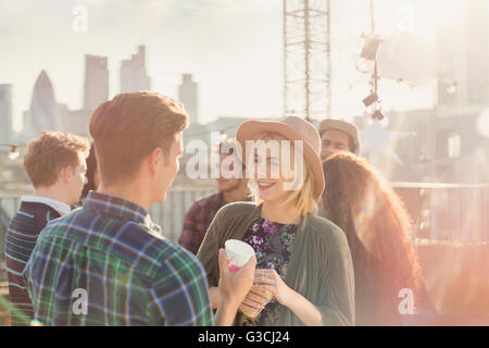 Junger Mann und Frau trinken und reden auf Party auf dem Dach Stockfoto