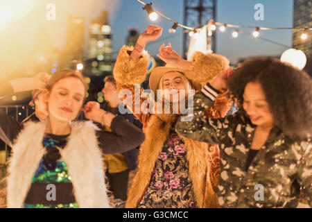 Junge Erwachsene Frauen tanzen auf nächtliche Rooftop party Stockfoto