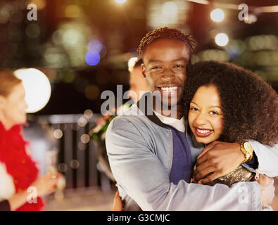 Porträt, Lächeln junges Paar umarmt auf party Stockfoto