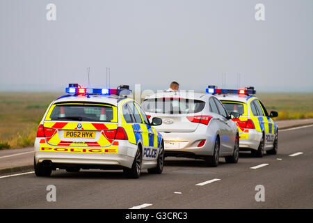 Britische Verkehrspolizisten auf Notruf 999. Streifenwagen der britischen Polizei, die an der Verkehrskontrolle am Marine Drive, Southport Promenade, Merseyside UK vorbeifahren. Zwei Polizeifahrzeuge wurden bei einer Verfolgungstaktik eingesetzt, und die Autofahrer wurden mit roten und blauen Lichtern angehalten. Stockfoto