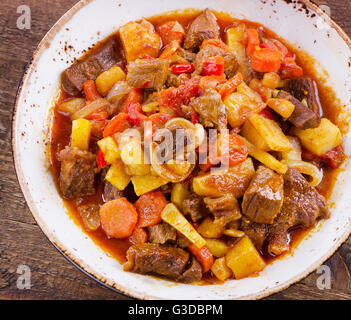 Irish Stew mit Gemüse auf einem rustikalen Holztisch. Ansicht von oben Stockfoto