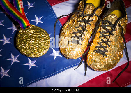 Goldene Schuhe sitzen neben Goldmedaille auf gay-Pride-Regenbogen-Band auf den roten, weißen und blauen Sternen und Streifen der amerikanischen Flagge Stockfoto