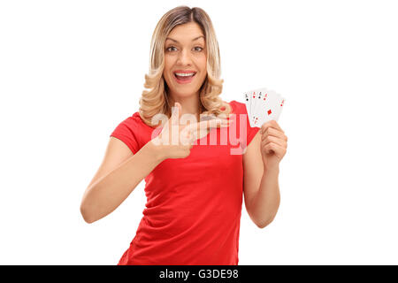 Fröhliche Frau hält vier Asse und zeigen sie mit dem Finger isoliert auf weißem Hintergrund Stockfoto