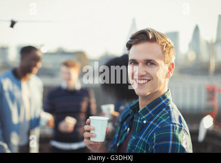 Porträt, Lächeln jungen Mann trinken auf Party auf dem Dach Stockfoto