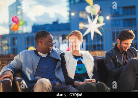 Junger Mann und Frau bei Nacht auf dem Dach Party flirten Stockfoto