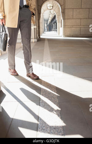 Corporate Geschäftsmann Wandern im sonnigen Kreuzgang Stockfoto